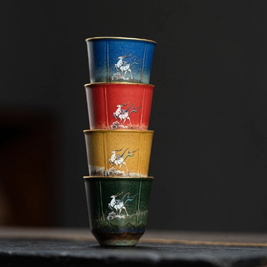 single green ceramic tea cup with deer and cloud motif, gold rim detail