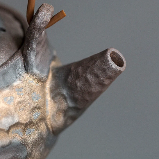 natural wicker wrapped handle detail on small ceramic teapot