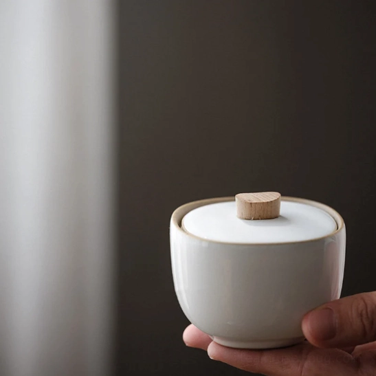 small size white ceramic tea storage jar with wood handle