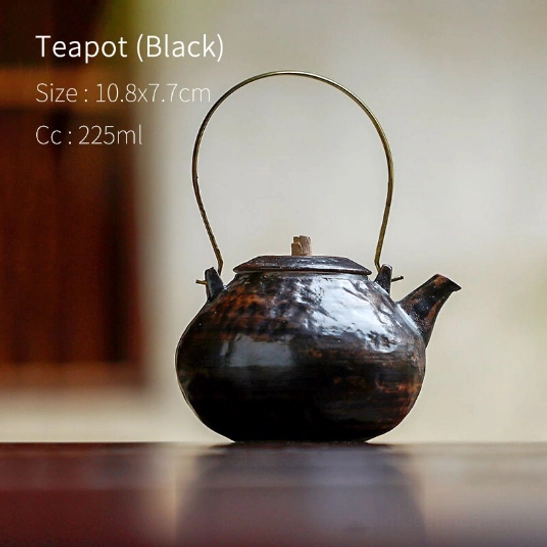Standalone black ceramic teapot with brass handle and built-in infuser