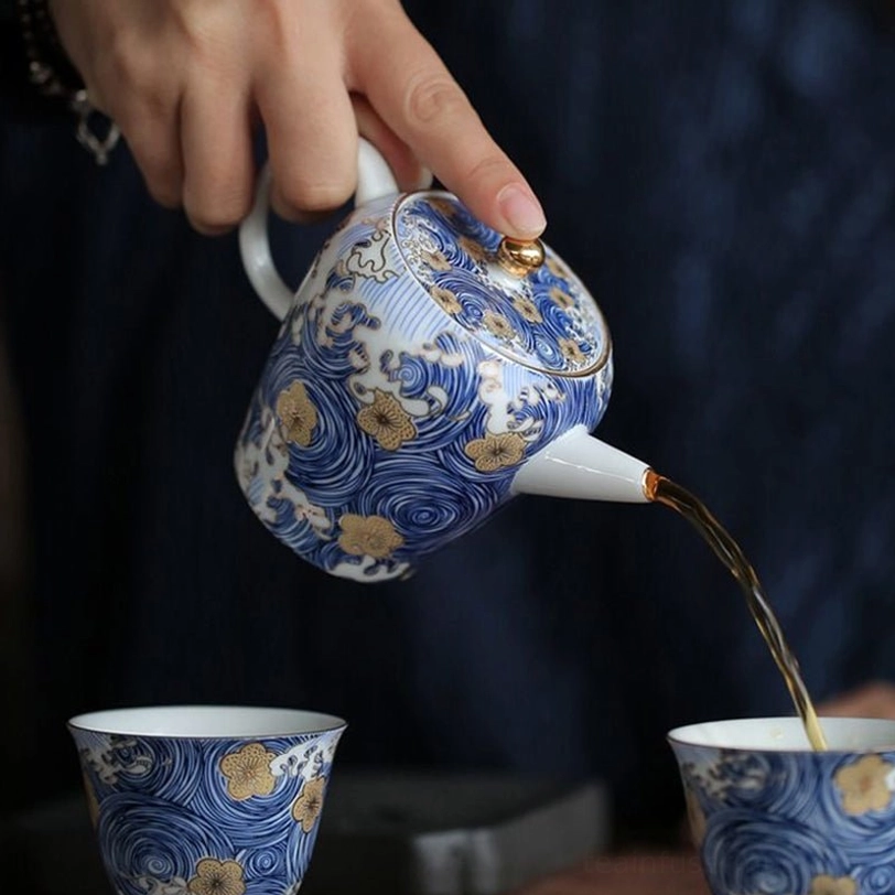 close up of blue wave and gold flower pattern on ceramic teapot