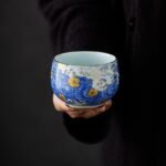 side view of hand-painted blue starry sky ceramic tea bowl with gold trim