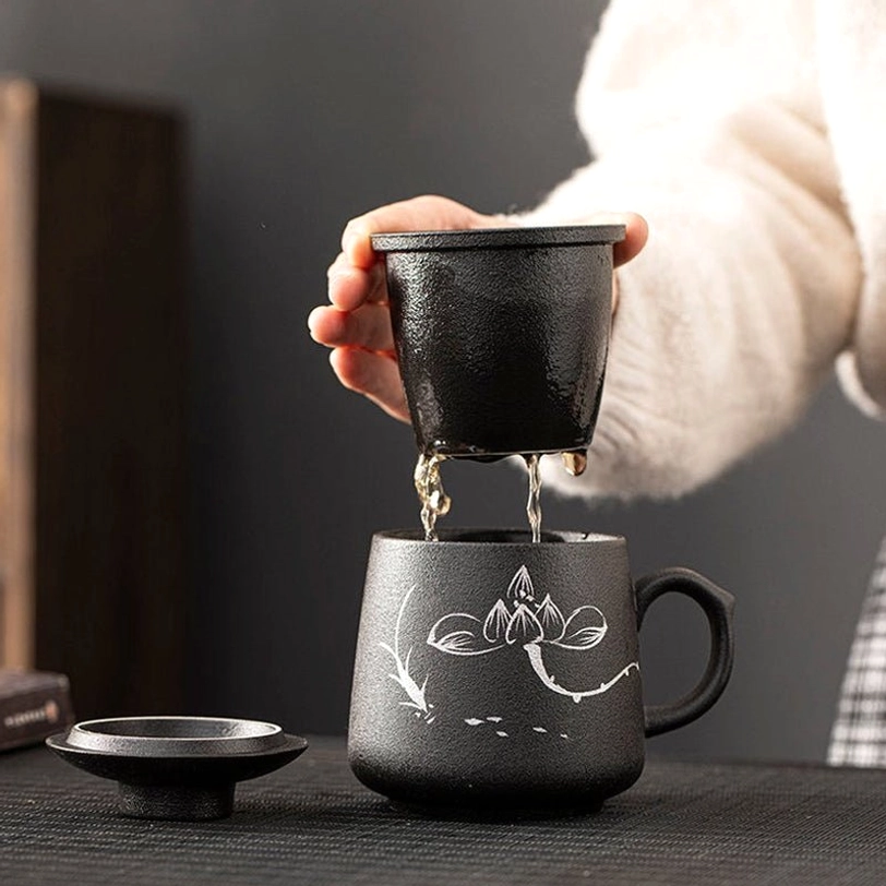 loose leaf tea steeping in ceramic infuser inside chinese painting tea infuser mug