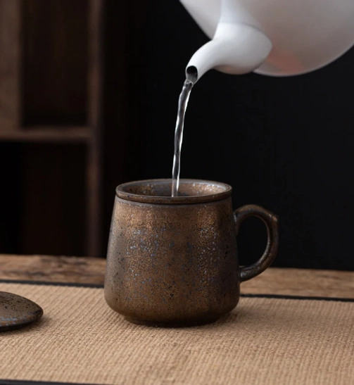 three quarter view of gourd ceramic tea infuser mug with infuser and lid