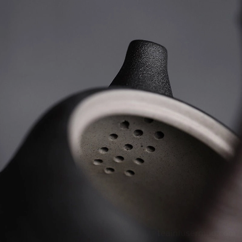 top view opening of small ceramic teapot with infuser