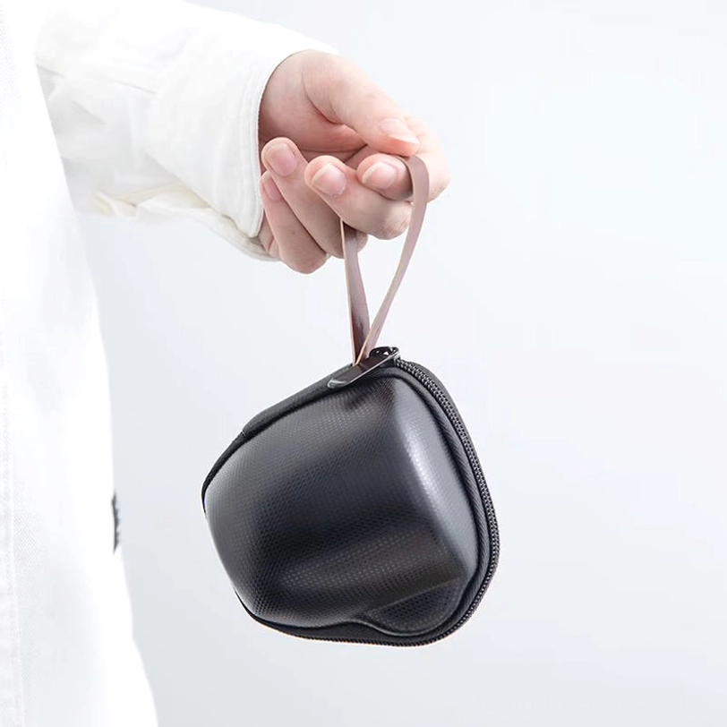 Ceramic travel tea set held by hand to show compact size