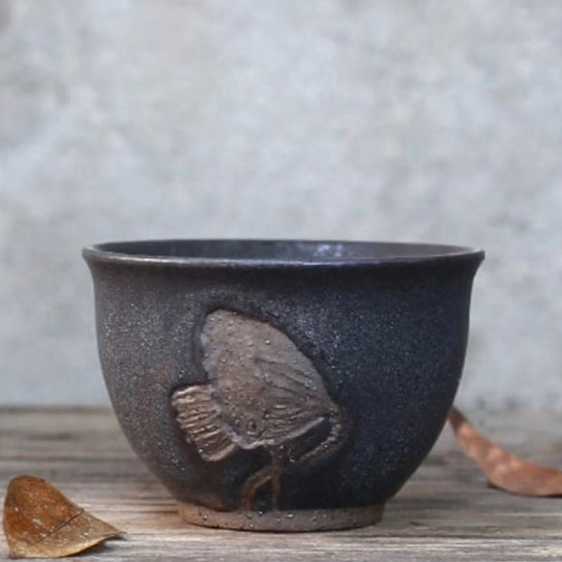 Close up of bird embossed pattern on travel tea set teacup