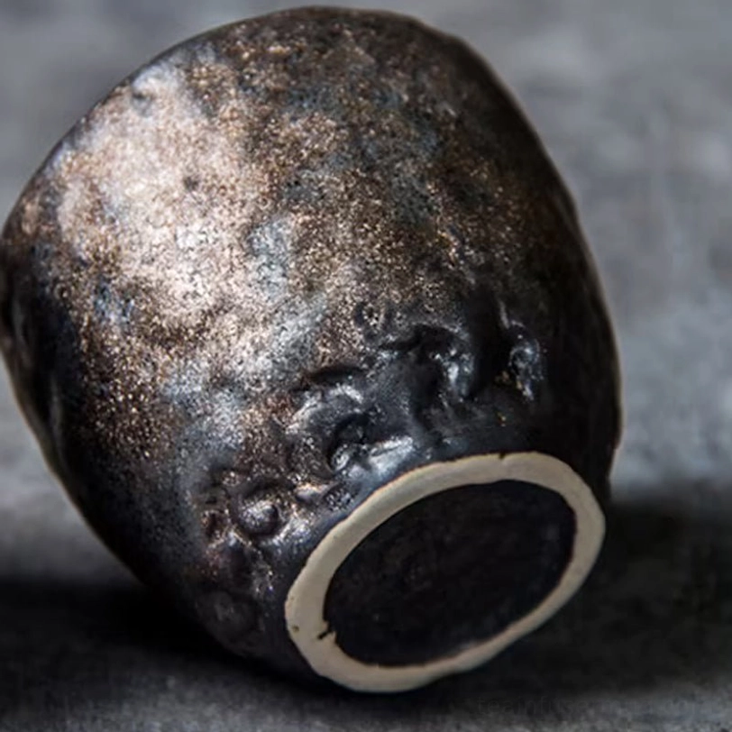 Two Chinese lotus clay tea cups displayed together on wooden background