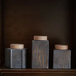 Collection of vintage ceramic tea storage canisters with natural wood lids in multiple shapes