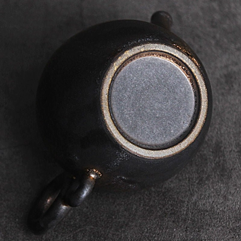 double ring handle close up of vintage gilded ceramic teapot