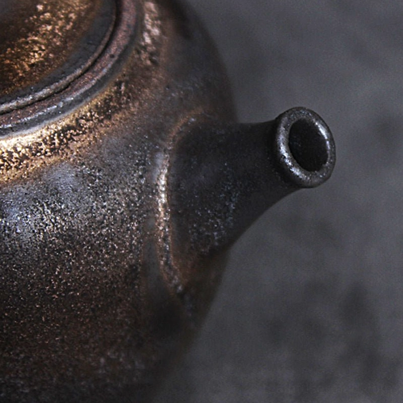 close up of the unique gilded textured surface of the ceramic teapot