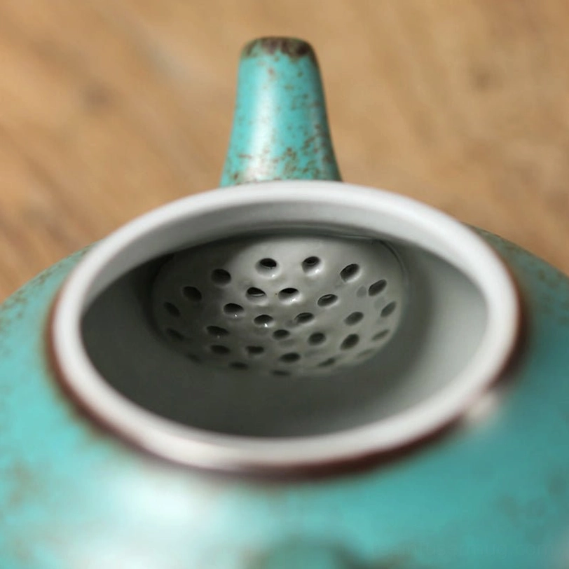 top view open vintage teapot showing porous infuser filter holes