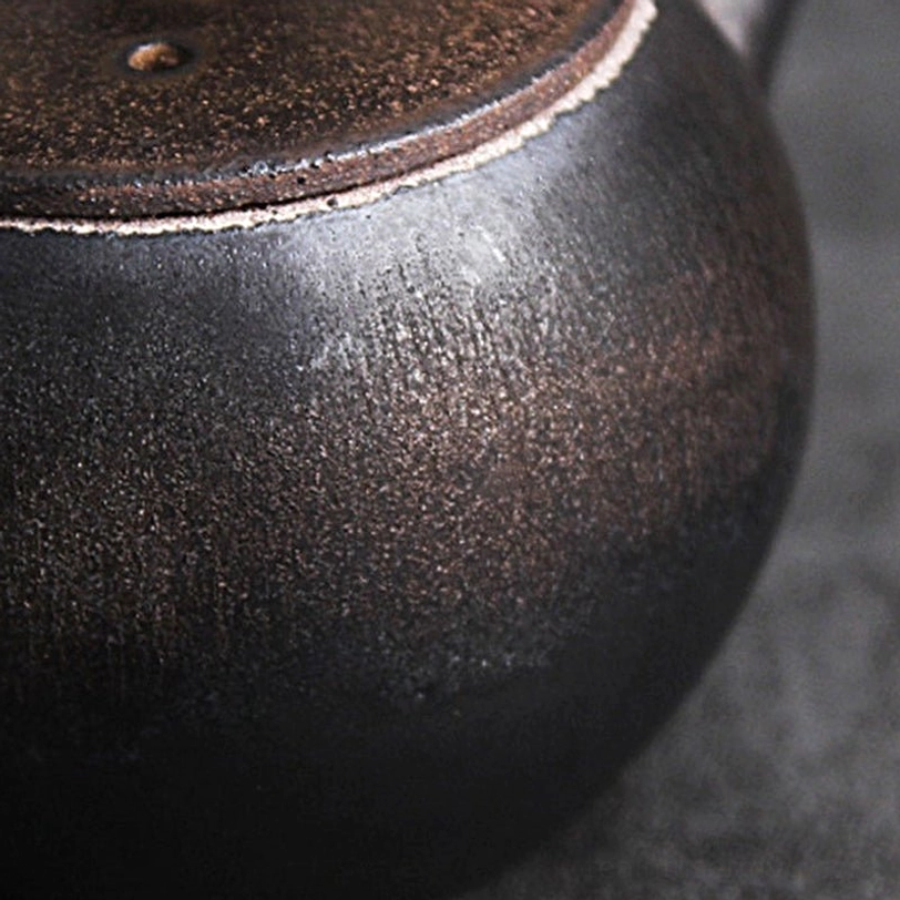 overall view of vintage textured black ceramic teapot with infuser