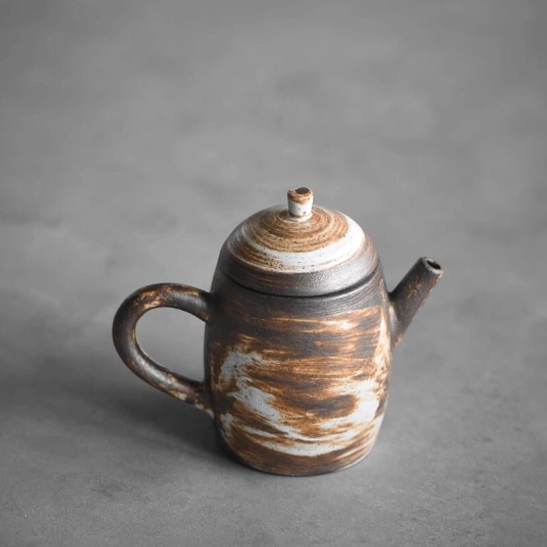 side view of textured wabi-sabi ceramic teapot with infuser