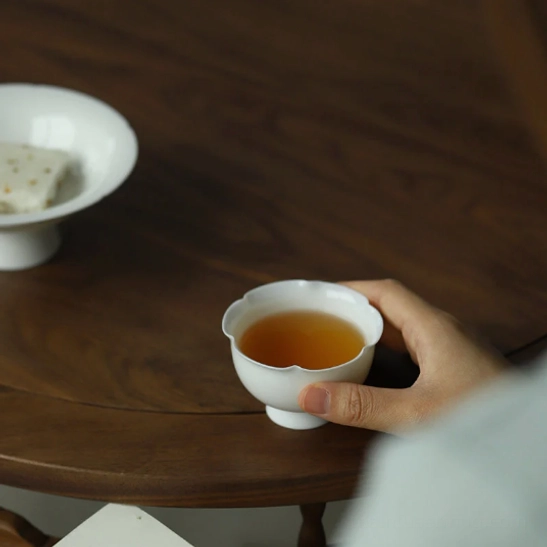 angle view of lotus petal rim on elegant white porcelain tea cup