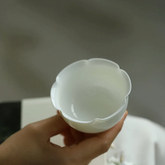overhead view of lotus petal shaped rim on white mini porcelain tea cup